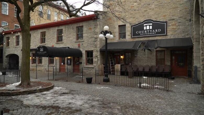 A gray brick building with a restaurant on an overcast winter day. 