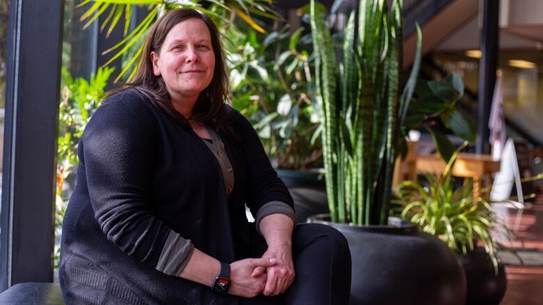 A woman sits in an atrium.