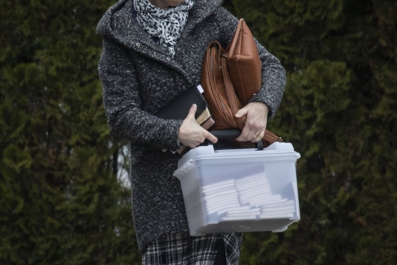 woman carrying box of hymn books