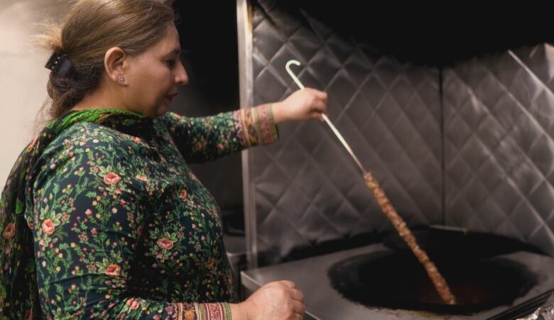 Zainab Kamboh cooks traditional halal meat on a skewer at Al-Buraq restaurant.