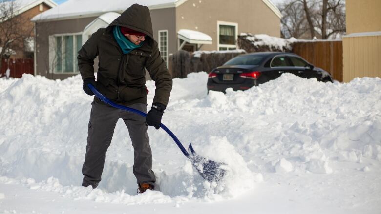 A man shovels snow.