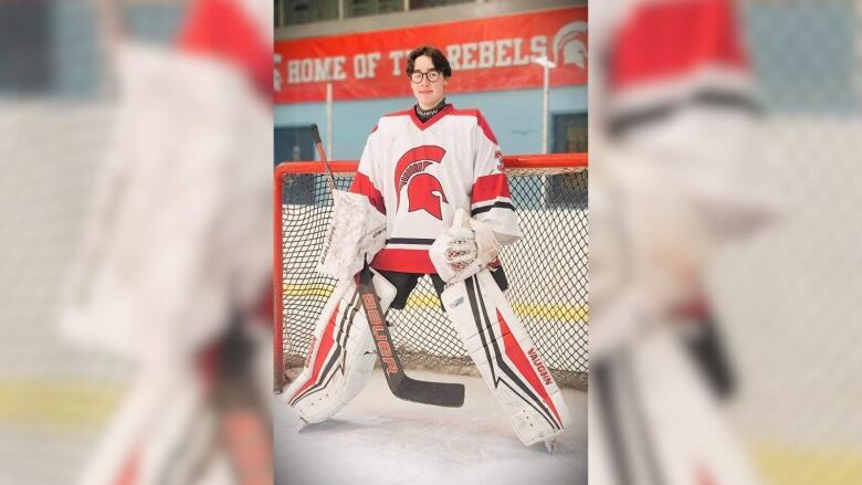 A goalie poses in front of the net. 