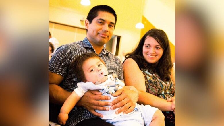 A man woman and child sitting on a couch.