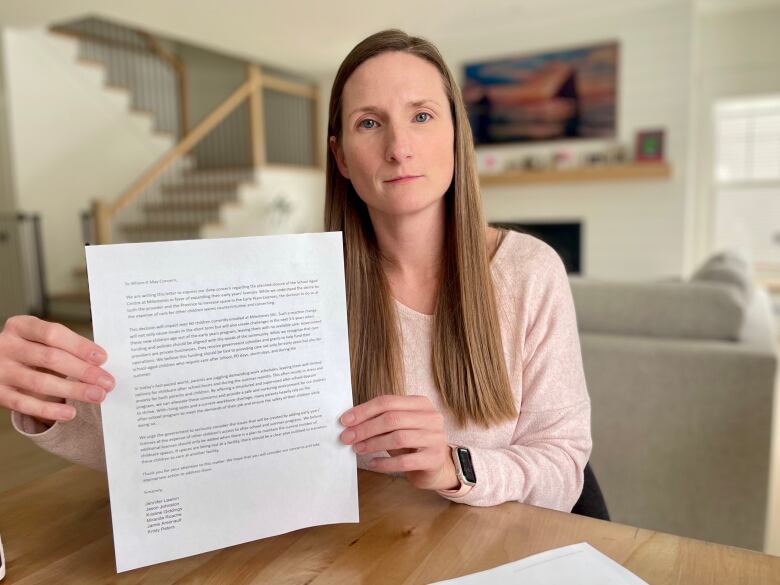 Woman holding up sheet of paper.