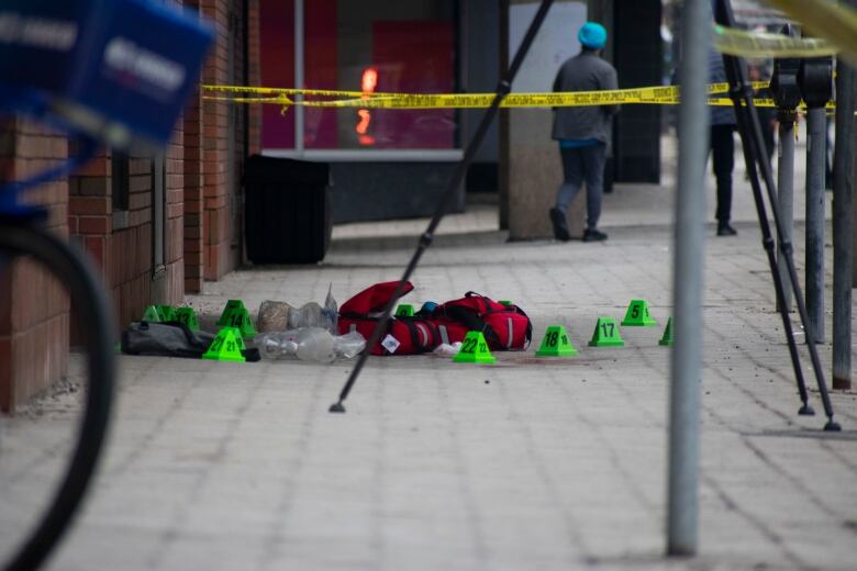 Paramedic kits and a blue shoe on a sidewalk.