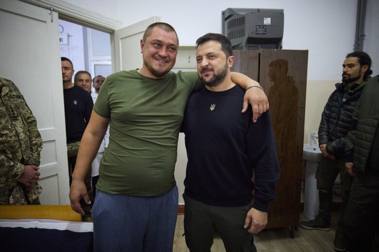 Ukrainian President Volodymyr Zelenskyy (right), poses for a photo with an injured Ukrainian soldier, at a military hospital in Mykolaiv, Ukraine, in October 2023.