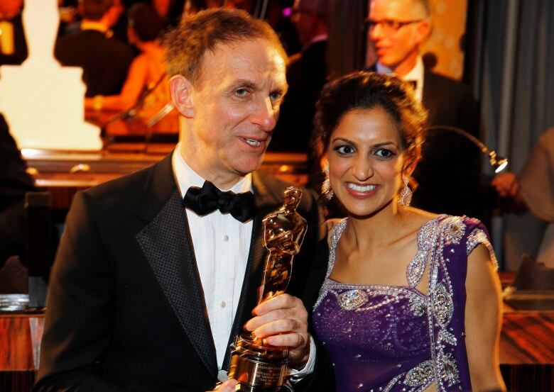 Canadian composer Mychael Danna holds his Oscar while standing next to his wife Aparna Danna.