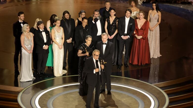 A group of people gather onstage.