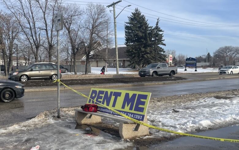 Yellow police tape is seen across a bench at a bus stop in the winter