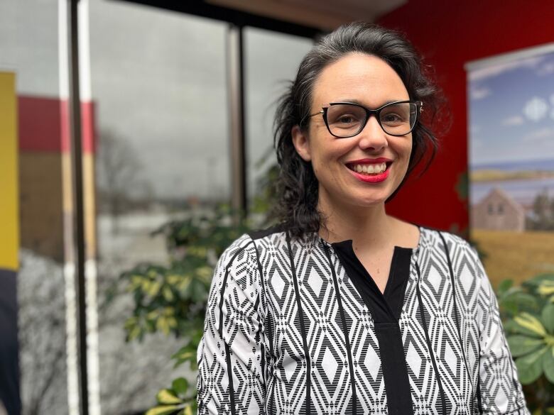 Woman with dark hair and dark framed glasses.