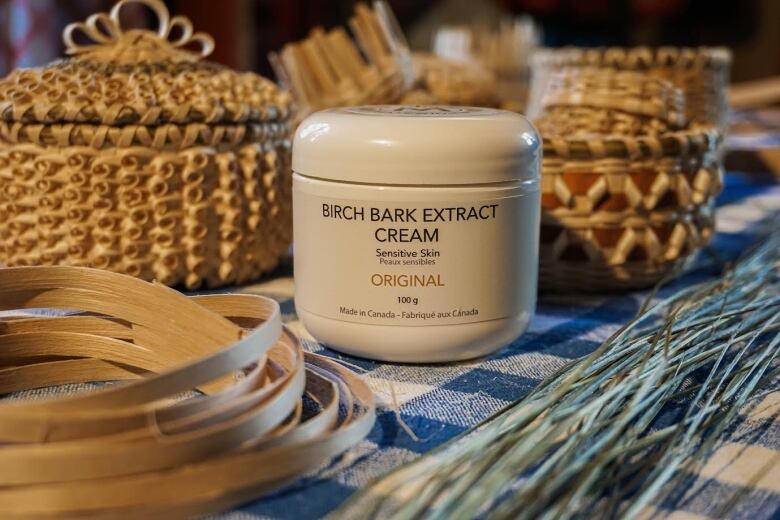 a bottle of birch bark extract sat next to Indigenous baskets