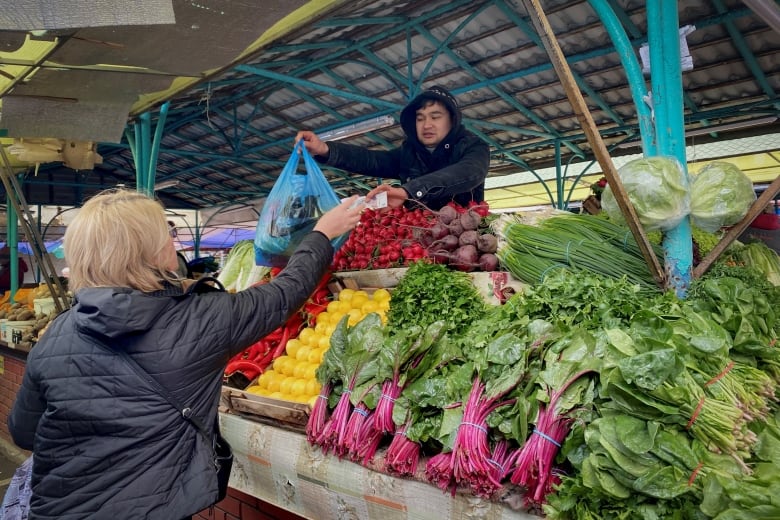 A woman shops for vegetables at a market in Moscow on October 10, 2023. 