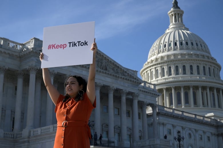 Woman holds sign that says #Keep TikTok