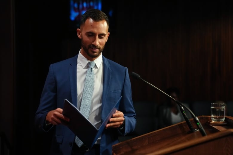 Man walks away from podium with binder