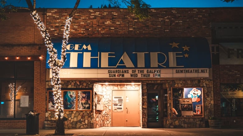 A small movie theatre pictured at night. 