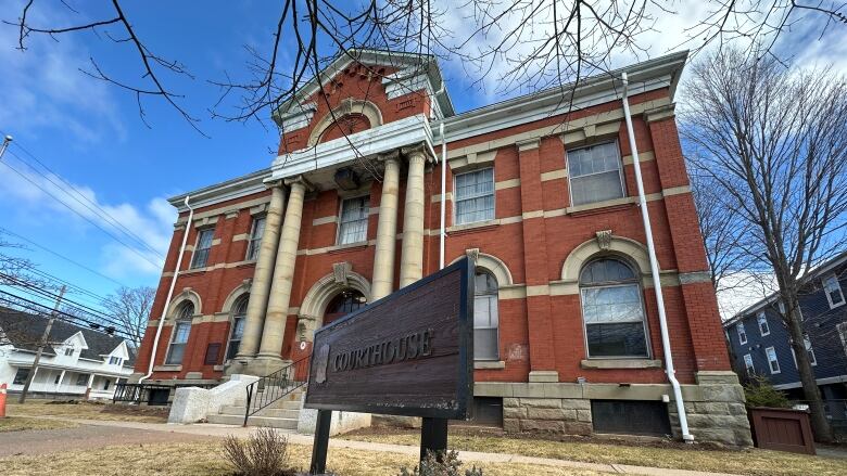 a historic brick building with a sign that says courthouse in front of it. 