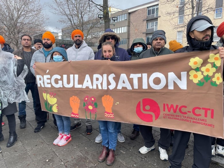 People stand holding a banner.