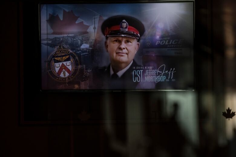 The face of a Toronto police officer named Jeffrey Northrup is shown on a plasma screen. 