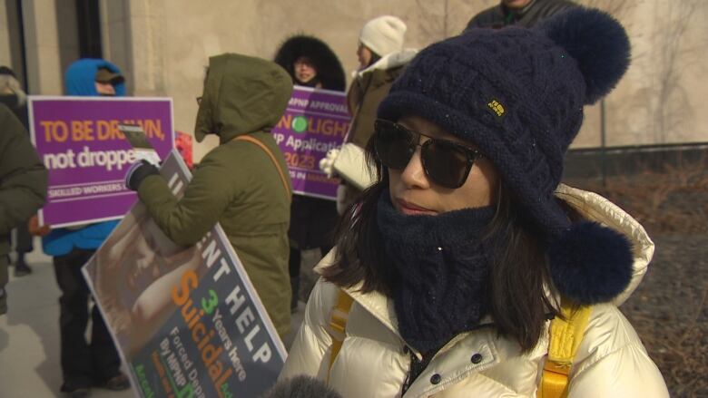 Woman with sun glasses and winter jacket poses for camera.