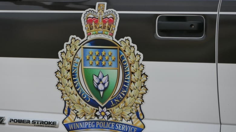 Winnipeg Police logo on the side of a police car parked outside of the home, closeup view 