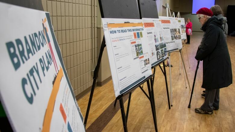 People look at signs explaining a city's future development plans.