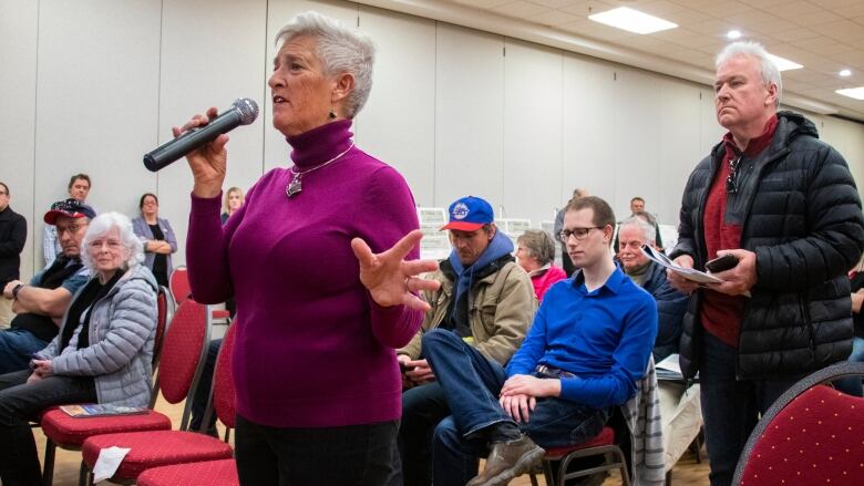 A woman speaks into a mic.