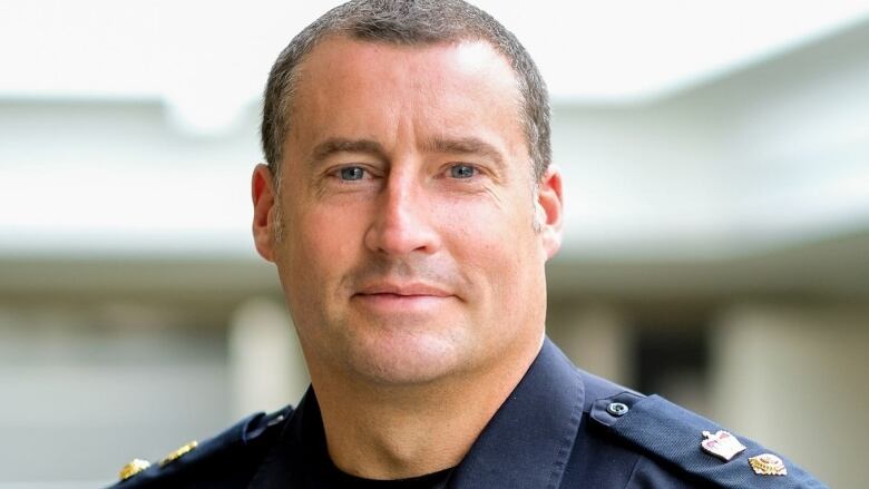 A man in a police uniform poses.