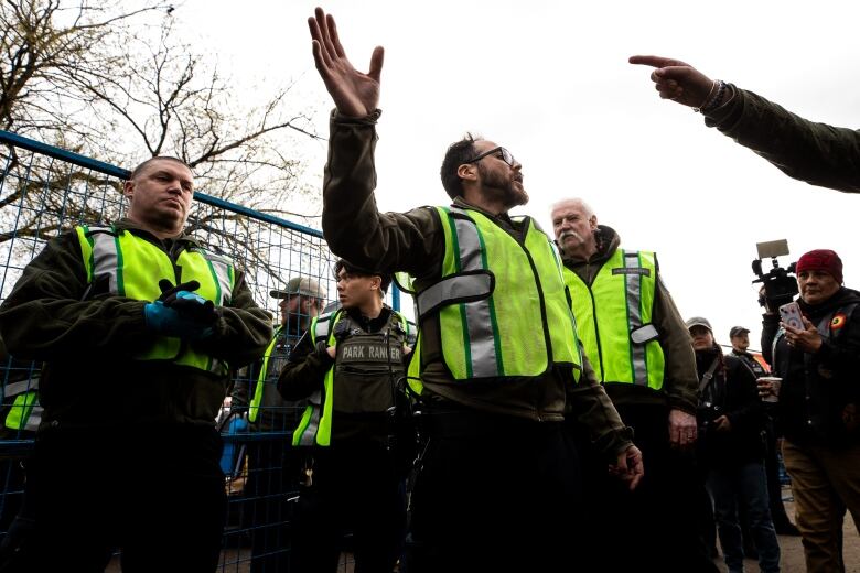 Vancouver Police officers are pictured near fencing put up around Crab Park during tent removals in Vancouver, B.C on Monday March 25, 2024.