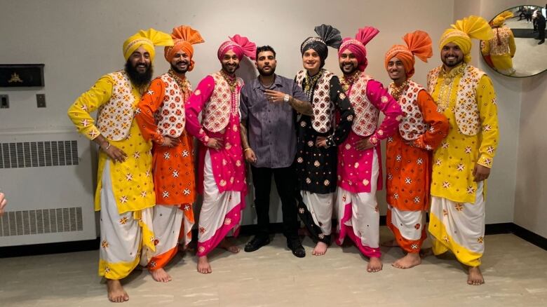 Men with colourful attire stand for a picture.