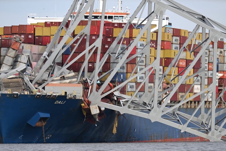 The steel frame of the Francis Scott Key Bridge sits on top of the container ship Dali after the bridge collapsed, Baltimore, Maryland, on March 26, 2024. (Photo by Jim WATSON / AFP) (Photo by JIM WATSON/AFP via Getty Images)