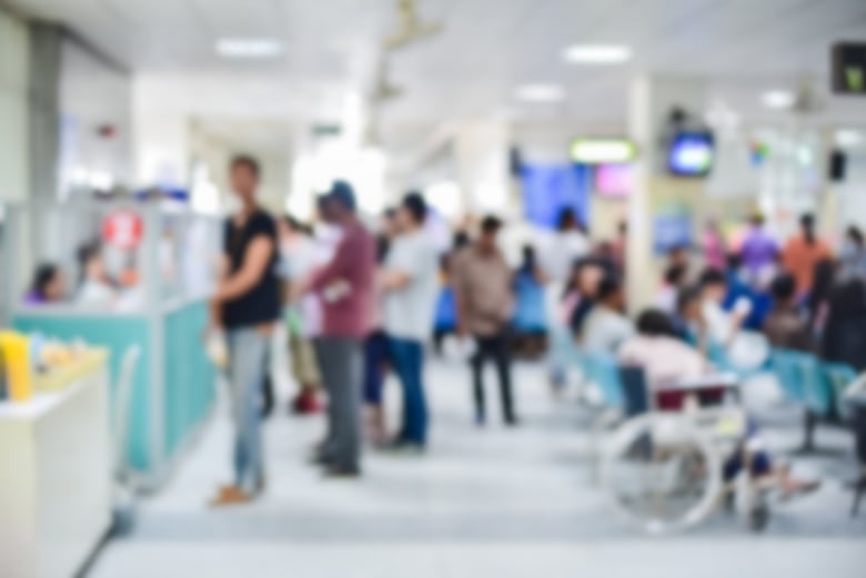 A blurred image of patients in a hospital waiting room.