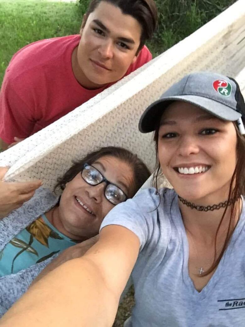 A group of Indigenous people on a hammock 