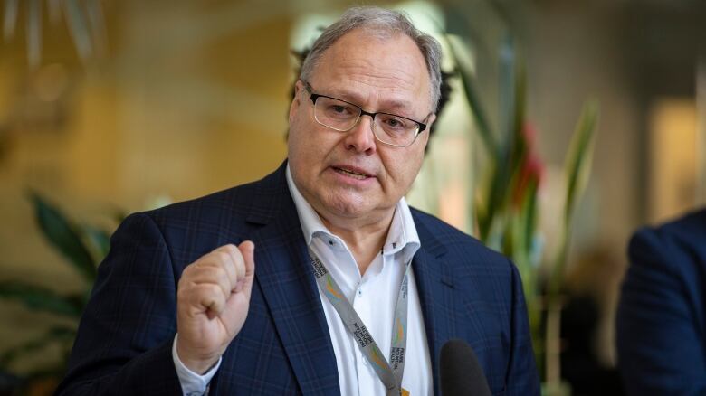 A man passionatly lifts his fist while speaking at a podium.