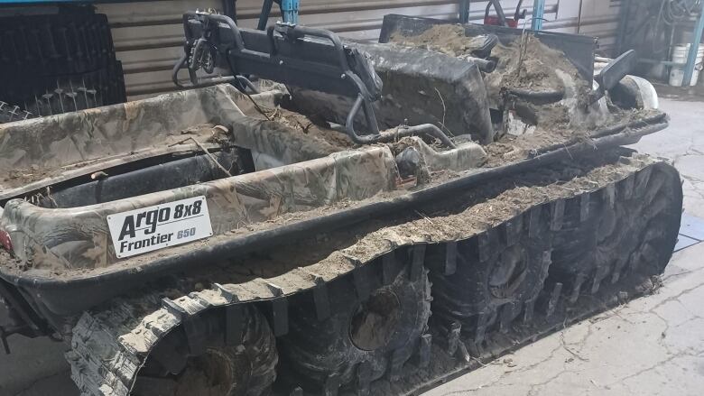 An Argo 8x8 vehicle covered in mud. 