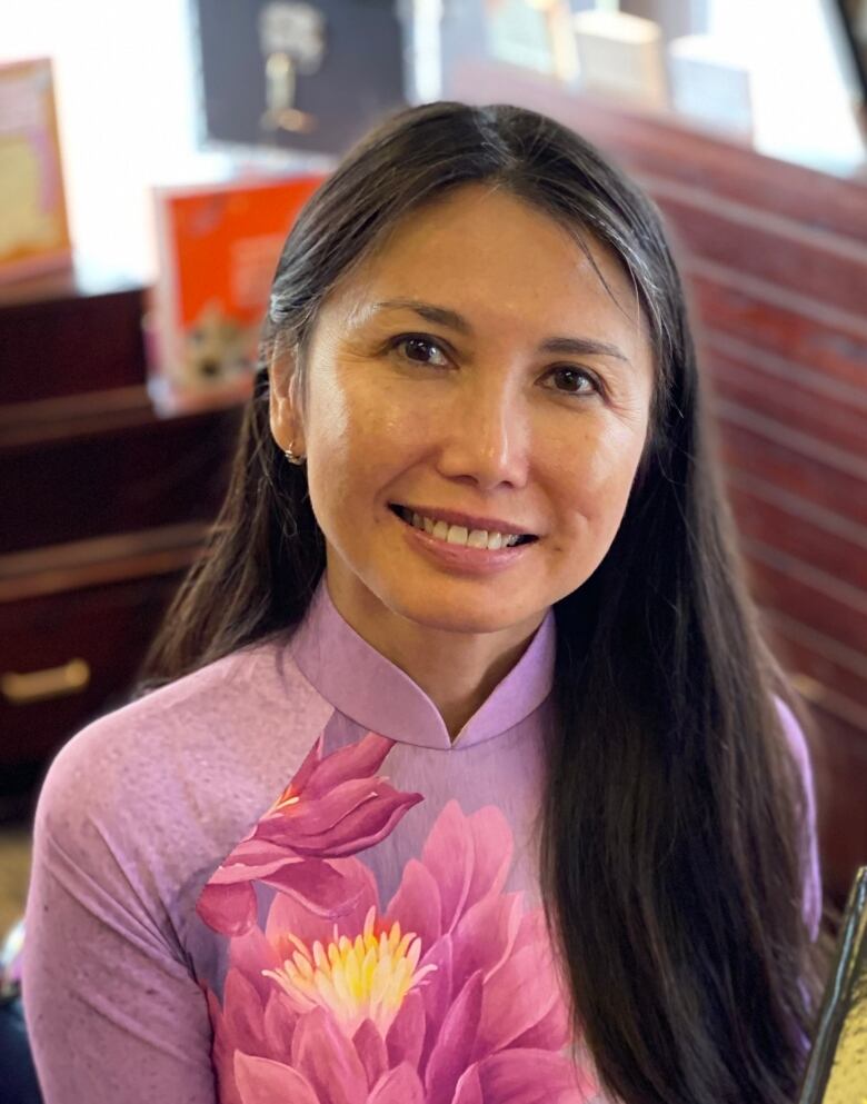 A woman smiles holding a book which reads Green Papayas.