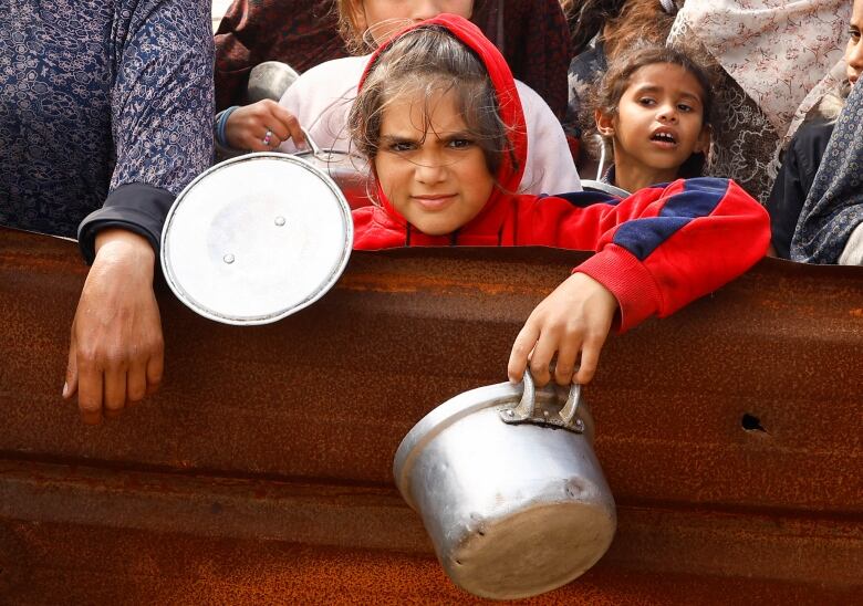 Displaced Palestinian children wait to receive free food at a tent camp, amid food shortages, as the conflict between Israel and Hamas continues, in Rafah in the southern Gaza Strip, February 27, 2024.