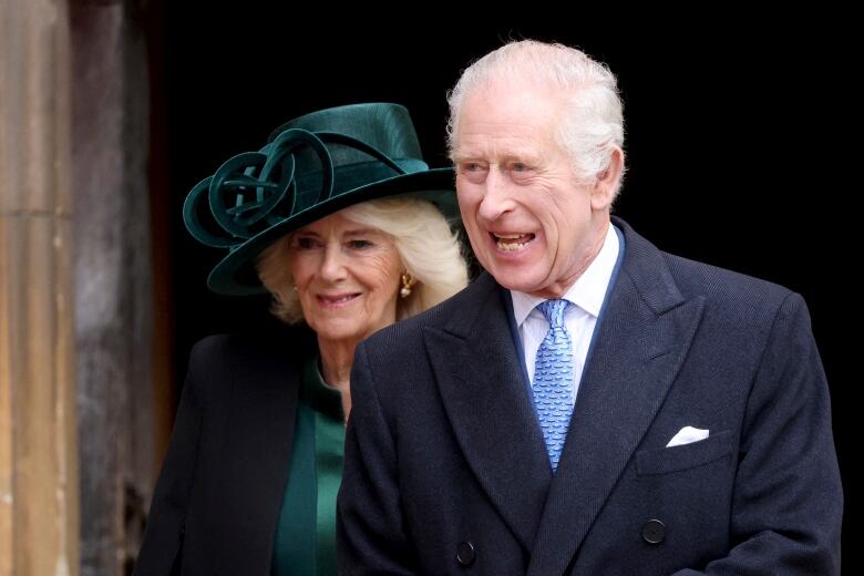 King Charles, on the right, walks with his wife Queen Camilla.