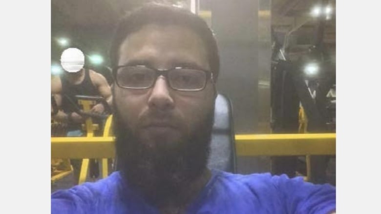 A man with a beard and glasses takes a selfie.