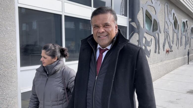 A man and a woman entering a building. 