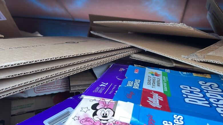 A pile of corrugated cardboard and a blue Rice Krispies cereal box.