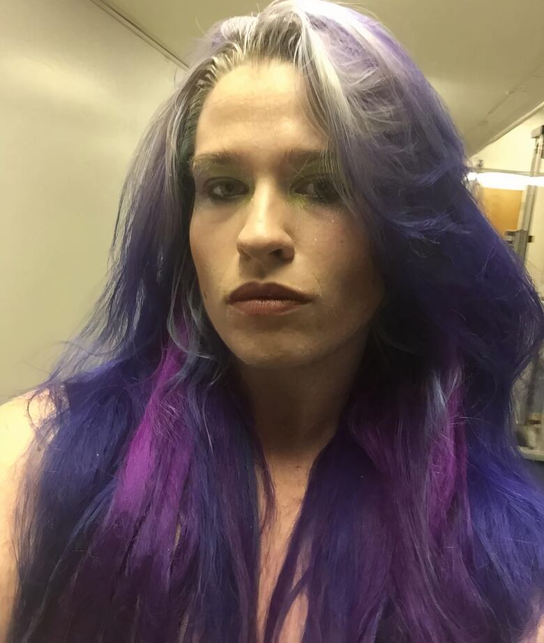 A close-up shot of a woman with purple hair.