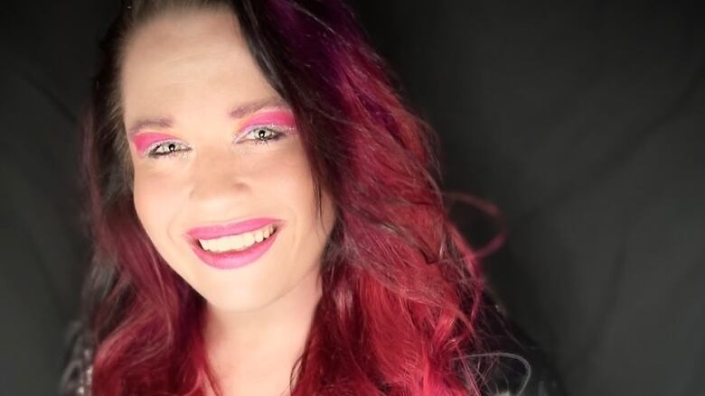 A woman with red hair smiling at the camera.