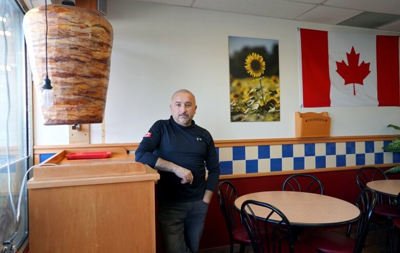 A man leans on a counter in a restaurant.