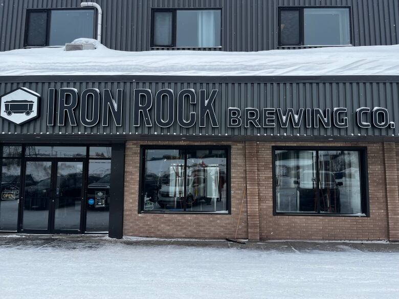 A snow-covered exterior sign reading Iron Rock Brewing Co.