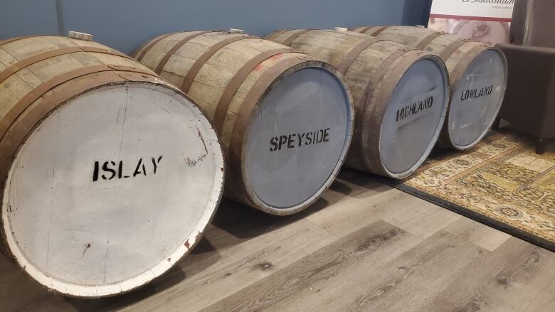 Four wooden barrels full mead lay next to each other. They are labelled 