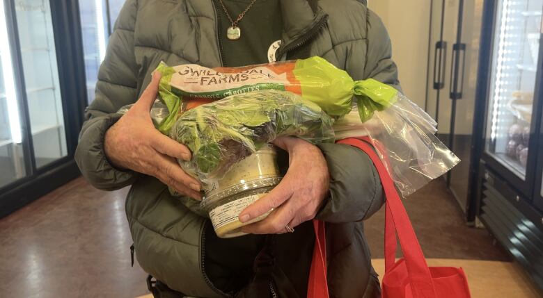 A person holds an armful of groceries.