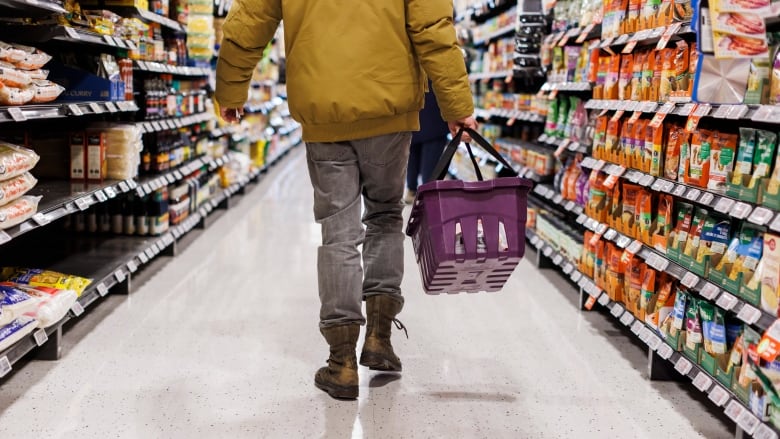 A man walks down a grocery store aisle