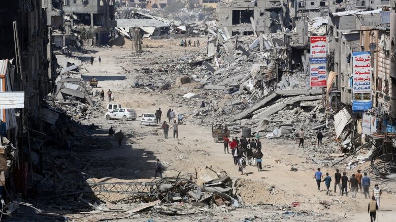 People look at destroyed residential buildings.