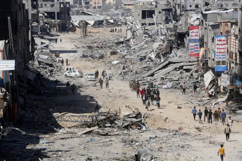 People look at destroyed residential buildings.