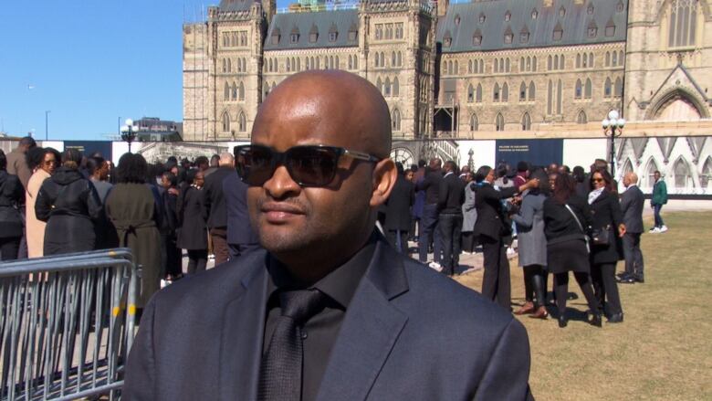 A man wearing sunglasses standing outside.